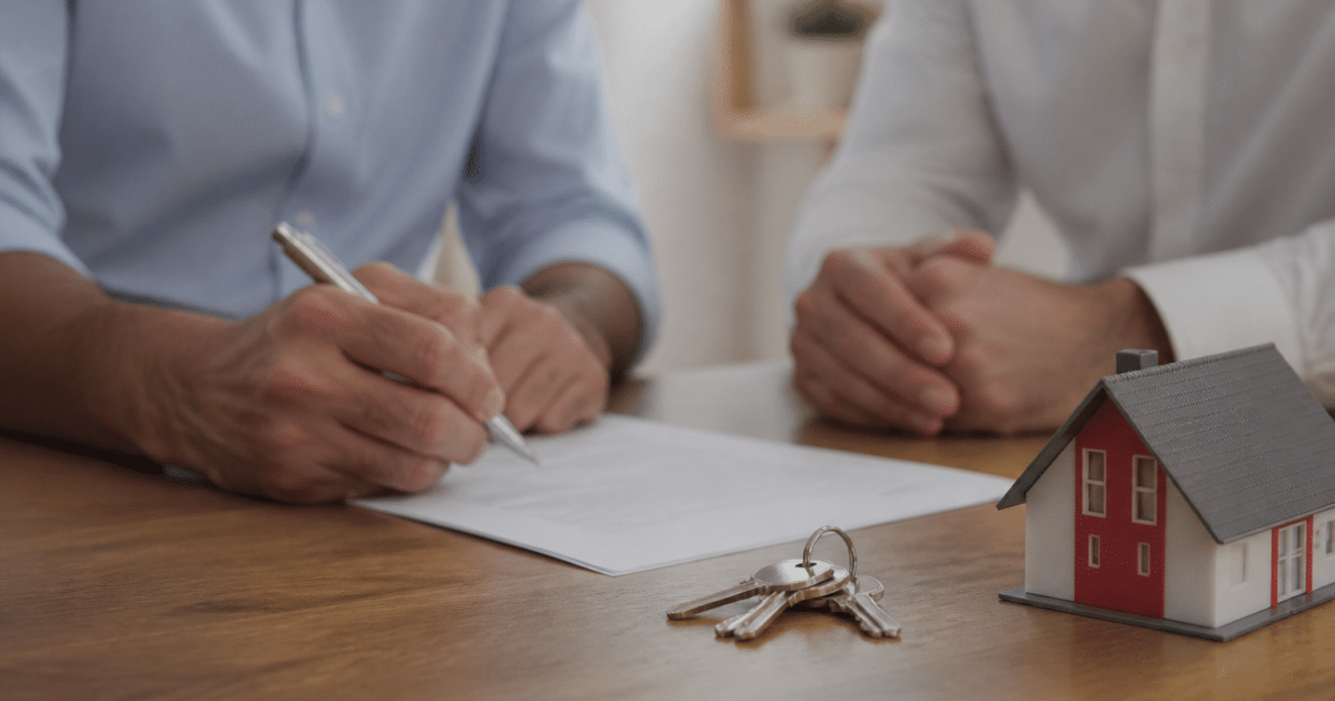 Contrat immobilier signe sur table avec cles et modele maison
