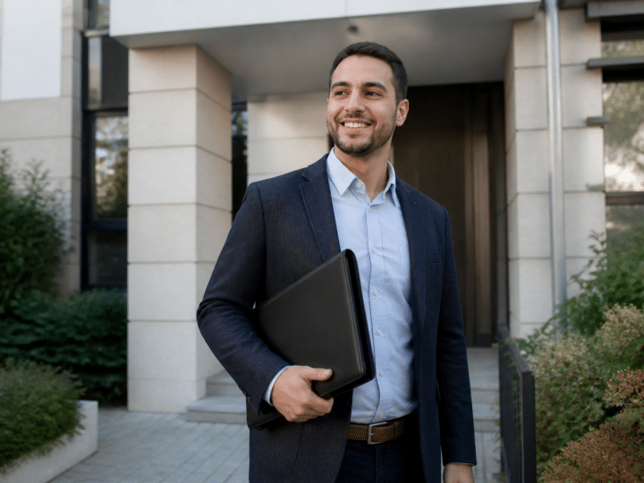 Agent immobilier souriant tenant dossier devant immeuble