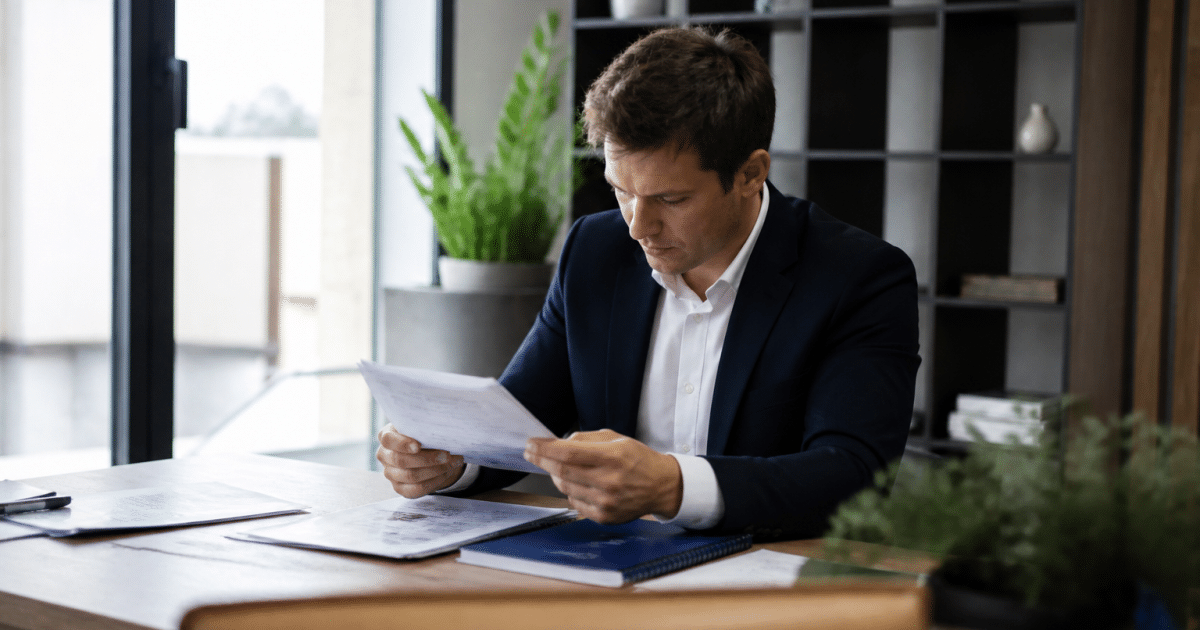 Professionnel immobilier examinant documents salaire bureau assis