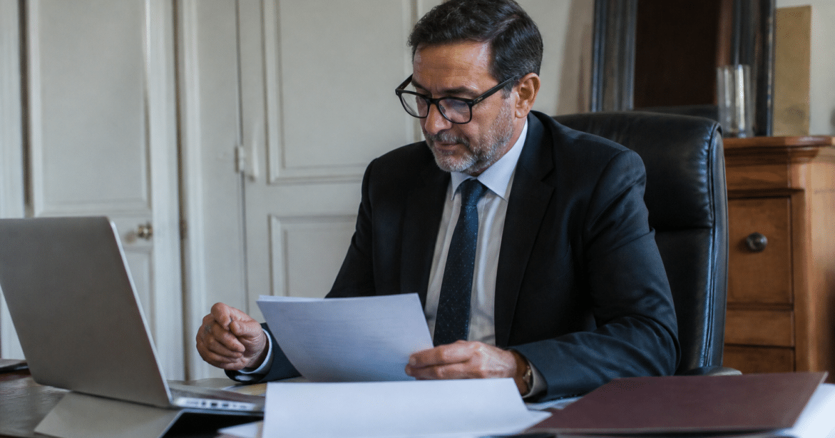 Avocat assis a son bureau consultant documents immobiliers par video