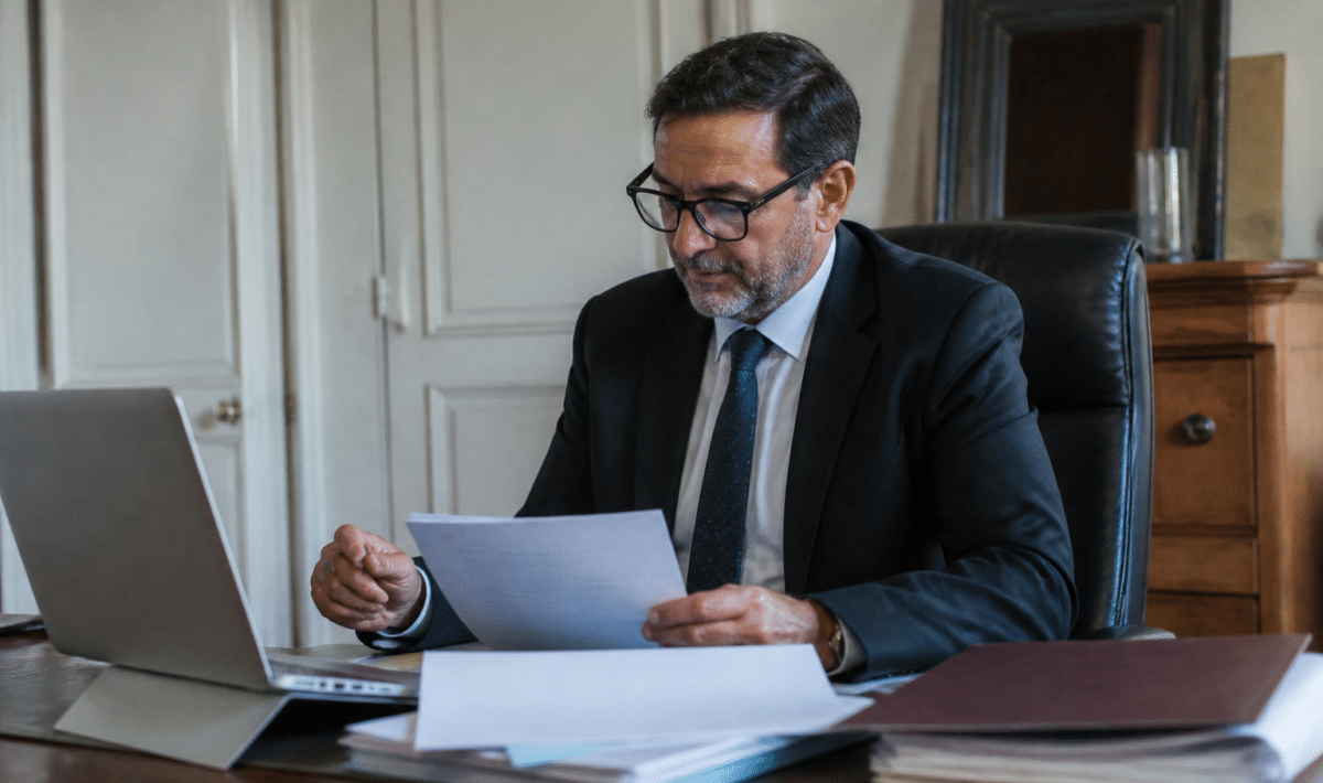 Avocat assis a son bureau consultant documents immobiliers par video