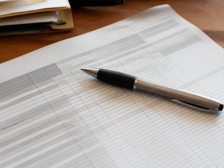 Formulaire administratif avec colonnes chiffres et stylo posé dessus