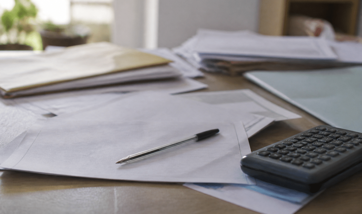 Documents administratifs etales sur bureau avec stylo et calculatrice