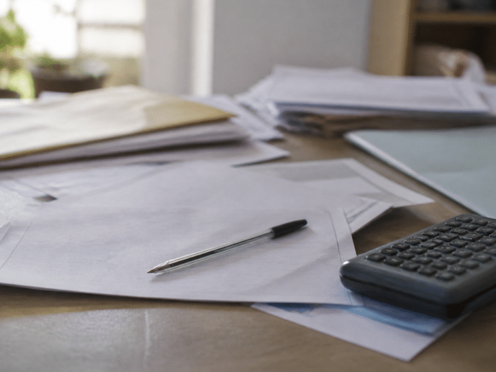 Documents administratifs etales sur bureau avec stylo et calculatrice