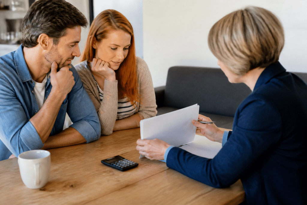 Agent immobilier montrant documents prix maison calculatrice