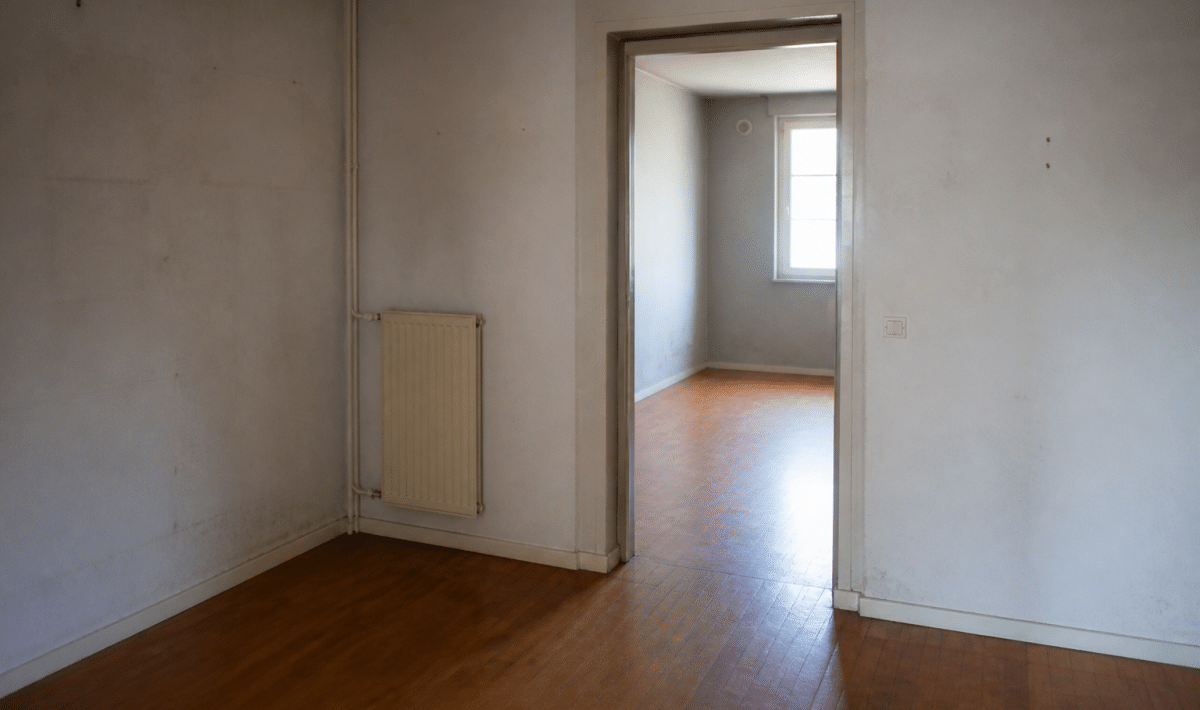 Appartement HLM vide avec murs nus et usures visibles