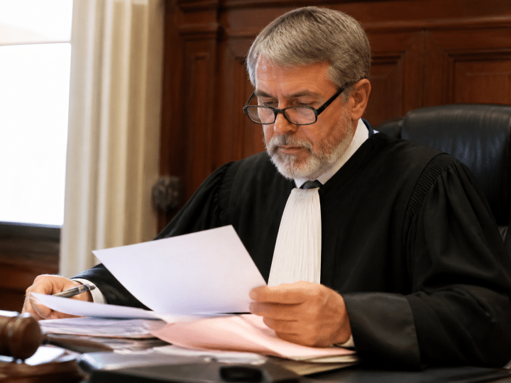 Juge assis derriere bureau examinant documents immobiliers