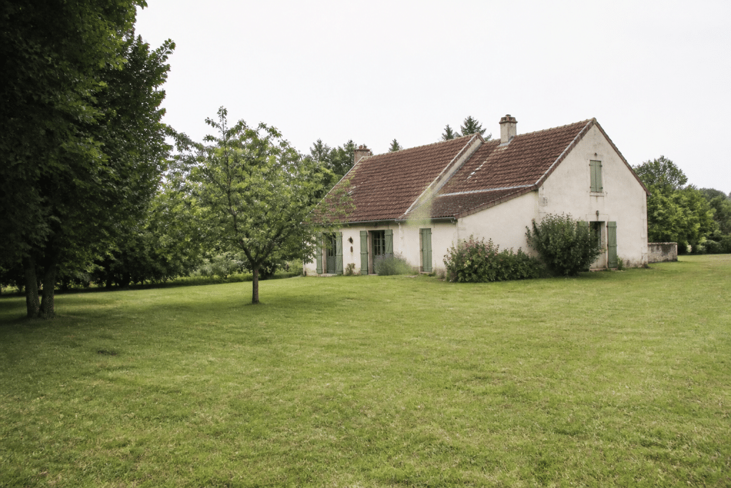 Maison rurale avec grand terrain herbeux entourant la propriete