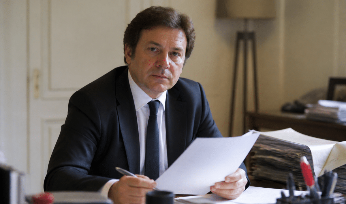 Notaire assis a son bureau tenant document officiel signe