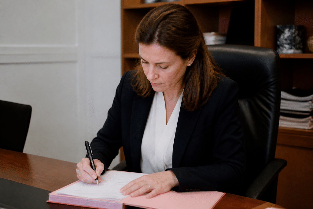 Femme notaire en costume formel signant document officiel