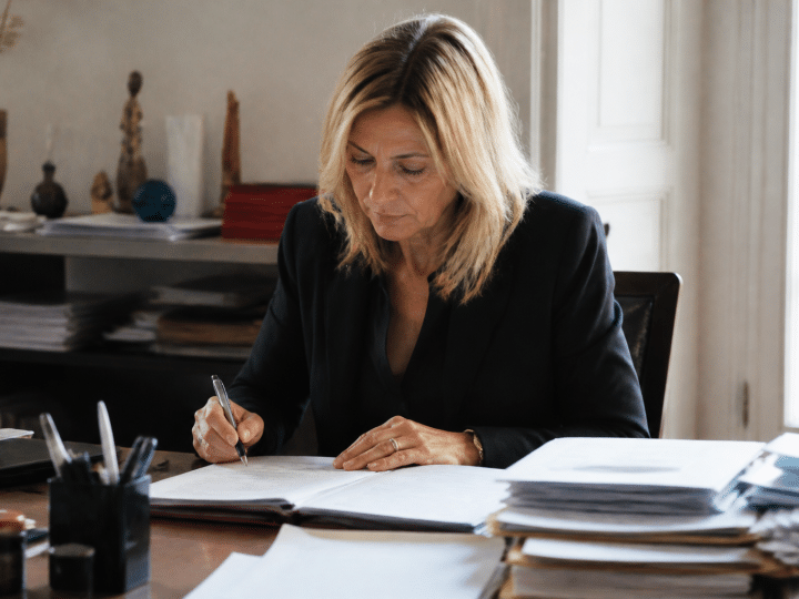 Notaire examinant documents immobiliers sur bureau avec stylo