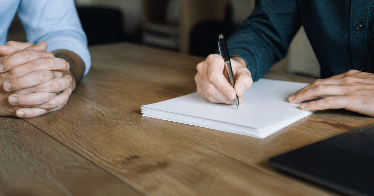 Contrat immobilier signé sur bureau avec stylo et documents empilés