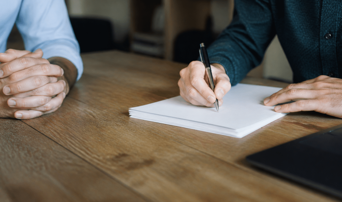 Contrat immobilier signé sur bureau avec stylo et documents empilés