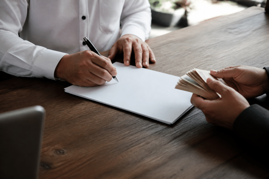 Signature de document immobilier avec stylo et argent liquide