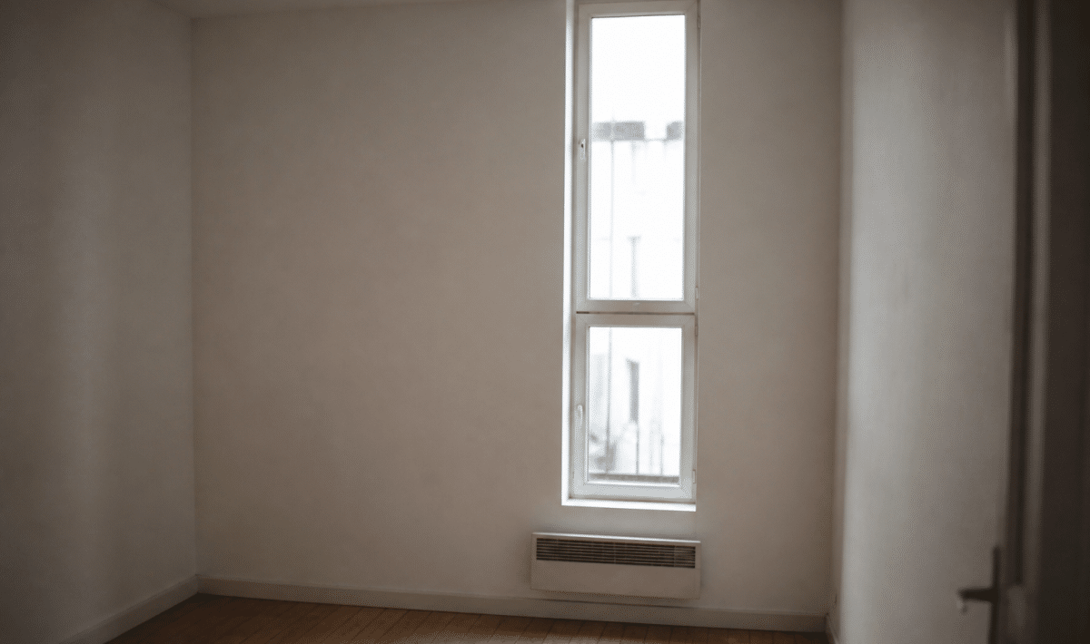 Petit studio vide avec murs blancs et fenetre etroite