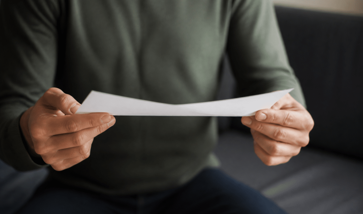 Personne tenant document pret immobilier suspendu entre mains