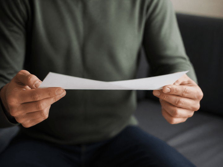 Personne tenant document pret immobilier suspendu entre mains