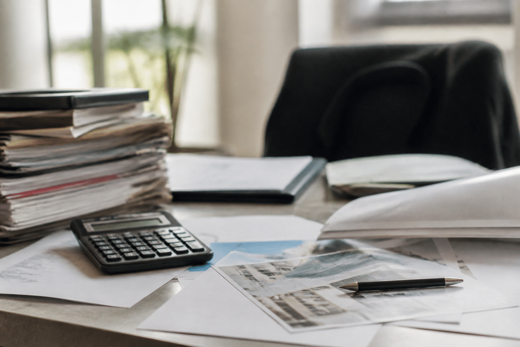 Documents immobiliers et calculatrice sur bureau professionnel